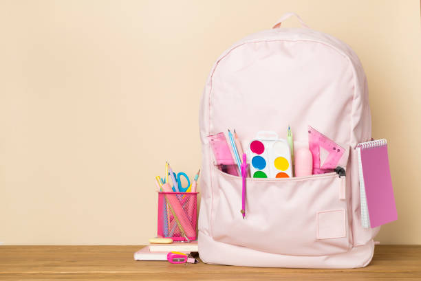istock Pink school backpack with stationery on wooden table 1540384979