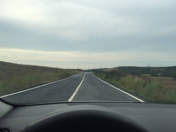 istock Driving on empty asphalt road, drivers point of view 1540391966