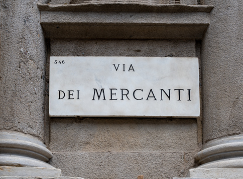 beautiful marble sign indicating Via dei Mercanti in Milan, flanked by stone semi columns. Via dei mercanti is an important pedestrian street in the center of Milan
