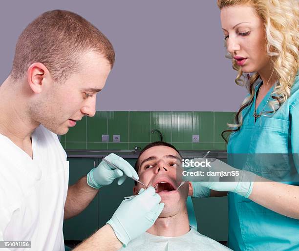 Photo libre de droit de Dentistes Travaillant Sur Un Patient banque d'images et plus d'images libres de droit de Adulte - Adulte, Blanc, Bouche humaine