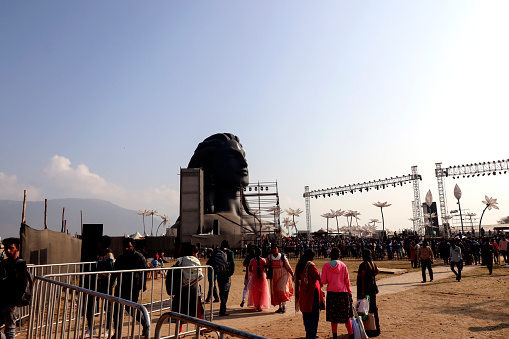 Coimbatore, Tamil Nadu, India –  February 18, 2023: Group of people gather together during mahashivratri festival celebration event in front of Aadiyogi Lord Shiva 112 feet tall statue.
