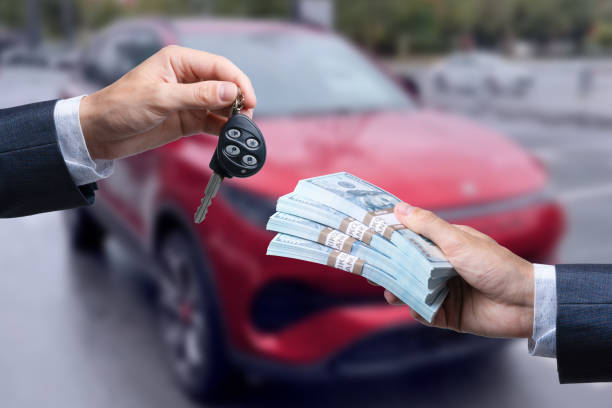 purchase deal of buy or rent new car. Hand with dollar money and car keys. finance. stock photo