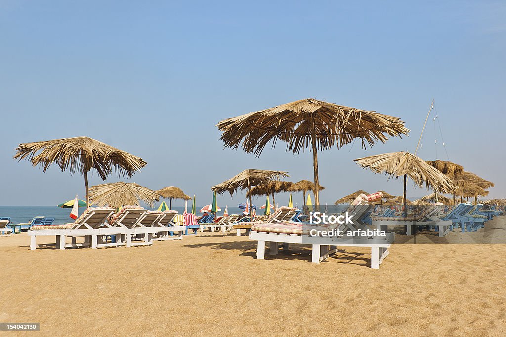 calangute goa india beach scene Landscape of Calangute beach resort in Goa India with a  beach scene loungers, sand, sun, parasols,  sea and blue cloudless skies Beach Stock Photo