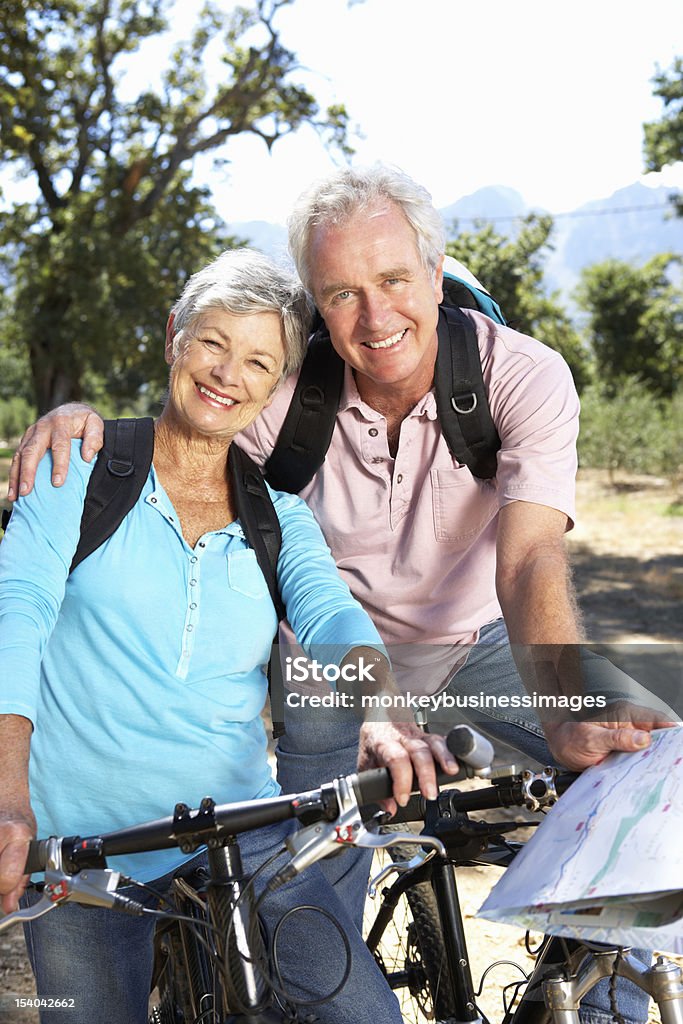 Старший пара с картой на страну велосипеде - Стоковые фото Весёлый роялти-фри