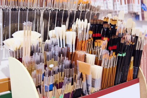 Assortment of paintbrushes on display shelf in an art store or school stationery shop. Fine art. Painting tools. Creativity. Close-up