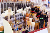 Assortment of paintbrushes on display shelf in an art store or school supplies shop. Fine art. Painting tools. Close-up