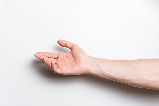 Close-up of a Caucasian male hand reaching palm up isolated on a white studio background.