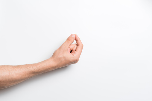 A close-up of a Caucasian male hand holding an invisible object or item for a copy space with an advertisement isolated on a white studio background.