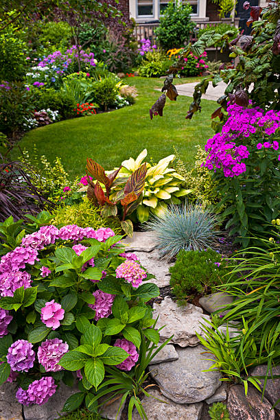 Colorful flowers in a neat garden Lush landscaped garden with flowerbed and colorful plants yard grounds stock pictures, royalty-free photos & images