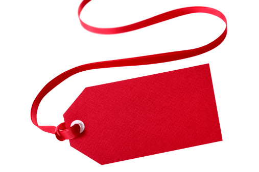 Red gift tag or price ticket with red ribbon isolated on white.  Sharp focus on the tag and gradually blurred ribbon with distance.  Alternative version shown below:
