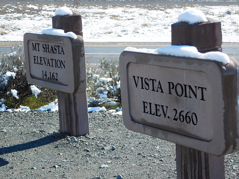 Snow-accents signs noting height of Mt. Shasta and the vista point.