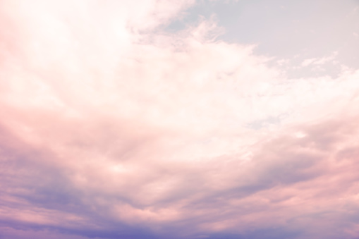 view of a surreal sky with purple clouds and sunshine on a summer day. dreamlike, fantasy, romance and dynamic.