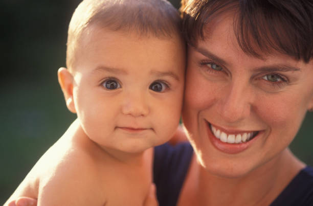 Portrait of mother and baby boy outdoors stock photo