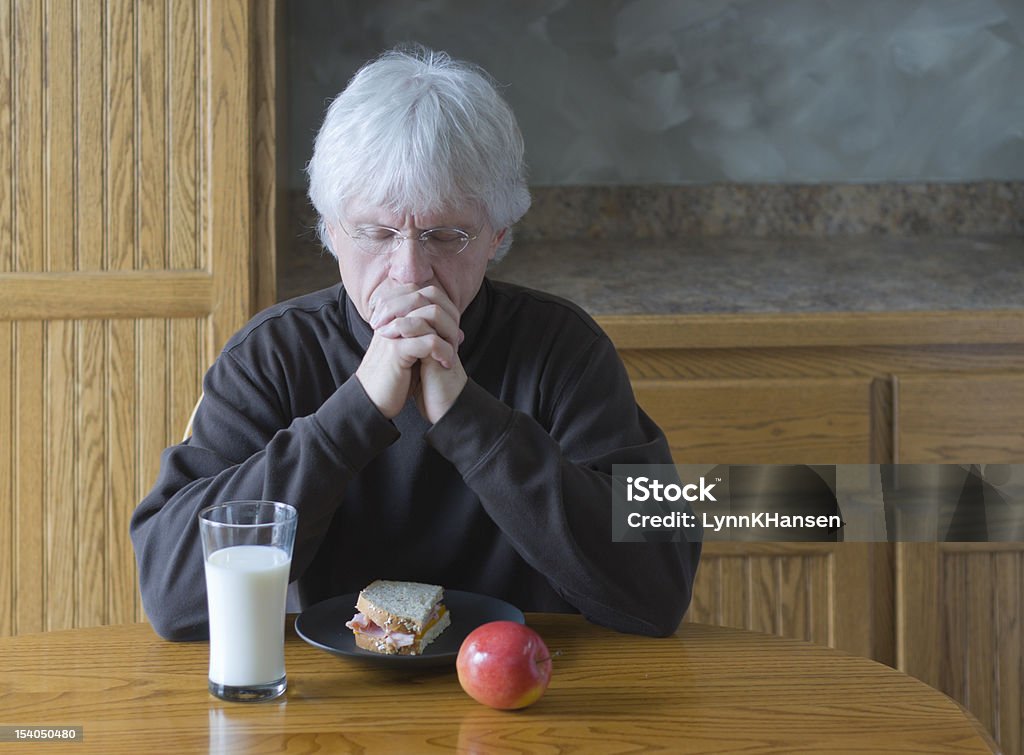Hombre maduro rezar antes de comer - Foto de stock de Adulto libre de derechos