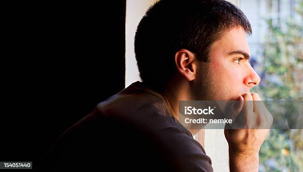 Homem Triste Olhando Para Fora Da Janela - Fotografias de stock e mais imagens de Esperar - Esperar, Olhar Através da Janela, Adulto