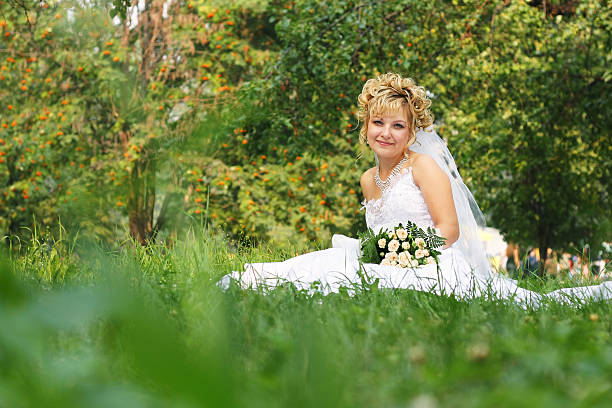 Happy bride at a park in grass stock photo