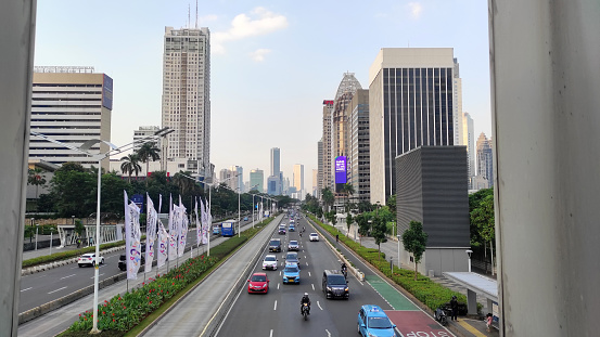 Jakarta, Indonesia - July 10, 2022. Capital highway between skyscrapers with heavy vehicle traffic.