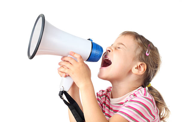 Little girl screams in megaphone stock photo