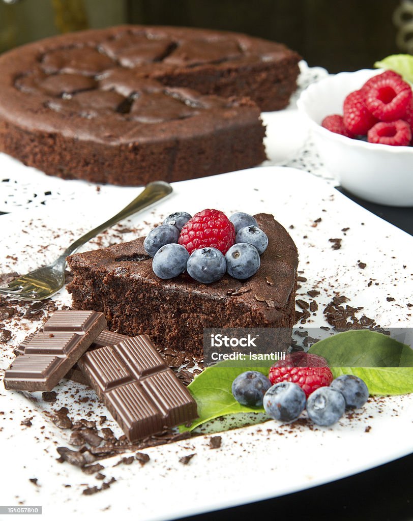 chocolate cake with fresh berry chocolate cake with fresh berry on white dish and black background Baked Pastry Item Stock Photo