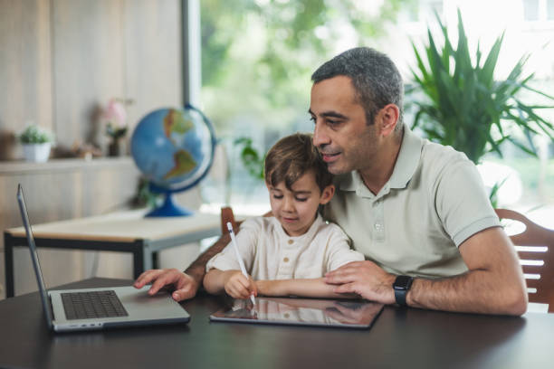 istock Father And Son Drawing Pictures On Digital Tablet 1540579198
