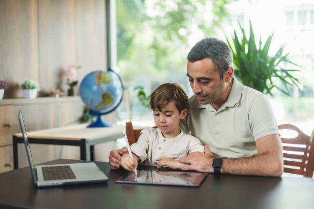 istock Father And Son Drawing Pictures On Digital Tablet 1540595210