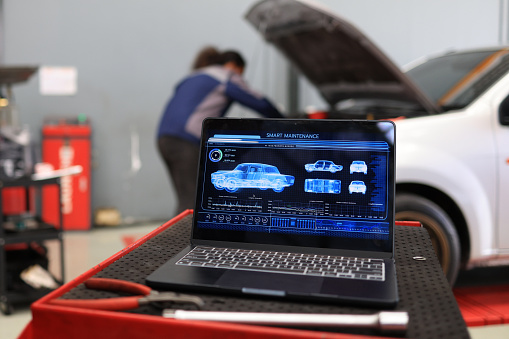 Foreman working on laptop with modern car service system control and manage care maintenance service system.