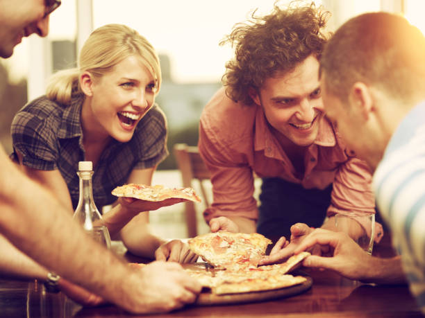 istock group of friends sharing a pizza 154065904