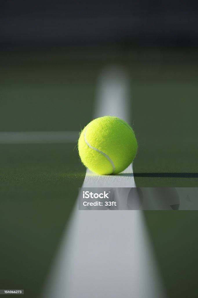 Tennis Ball on the Court Line Tennis Ball on the Fading Court Line Hardcourt Stock Photo