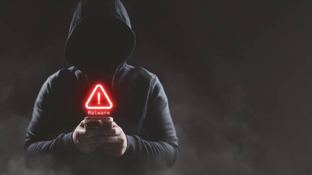 istock Hacker wear hood holding smartphone with red warning icon to launch ransomware malware attack on victim 1540680514