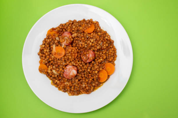 Lentils with chorizo and carrot on white dish. Typical Spanish recipe.