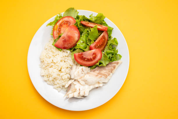 boiled fresh fish with boiled rice and fresh salad on dish