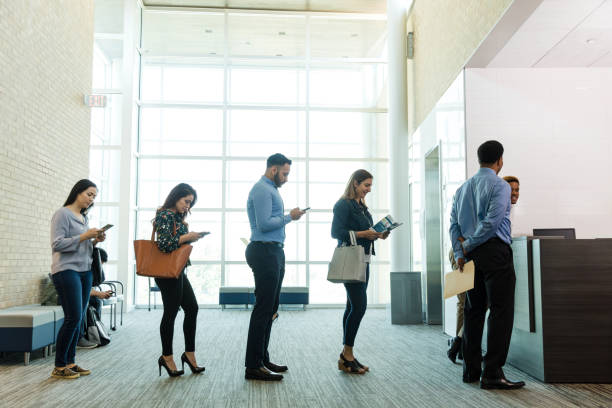 istock Various bank patrons waiting in line use smart phones 1540766454