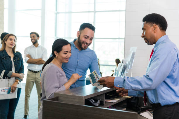 istock Young couple smiles as male teller talks about savings options 1540766457