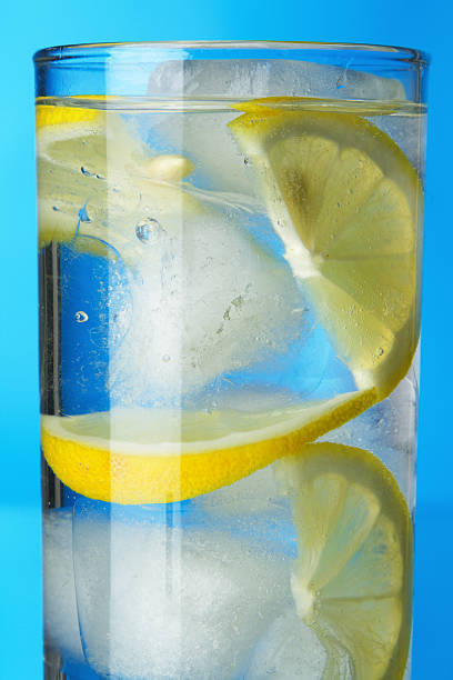 istock Glass of lemon ice water on blue background 154078248