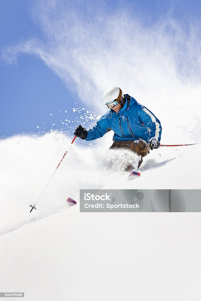 Powder Skiing Against Colorado Blue Sky Action shot of young man snow-plowing through powder snow in Loveland, Colorado. Skiing Stock Photo