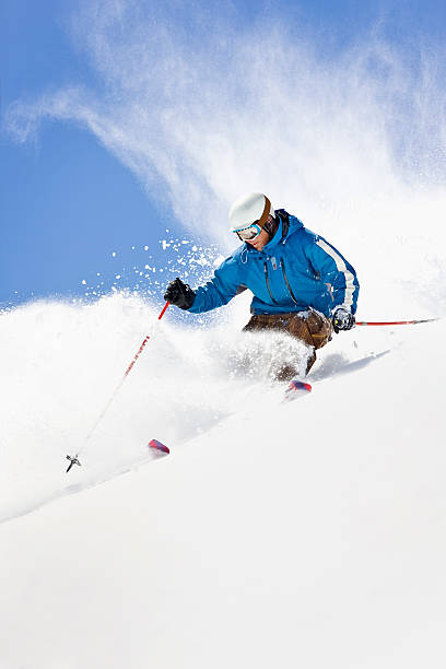 Powder Skiing Against Colorado Blue Sky Action shot of young man snow-plowing through powder snow in Loveland, Colorado. ski photos stock pictures, royalty-free photos & images