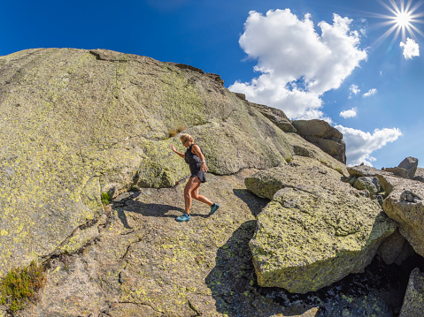 Woman in rugged and rocky terrain in high mountains