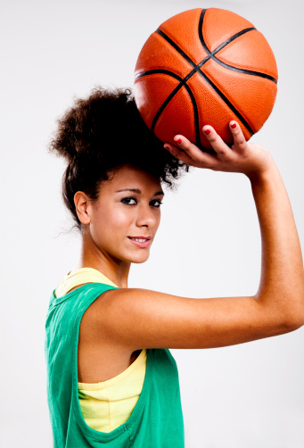Beautiful young athletic woman with basketball. Studio shot.