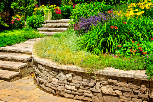 Natural stone landscaping in home garden with stairs and retaining walls