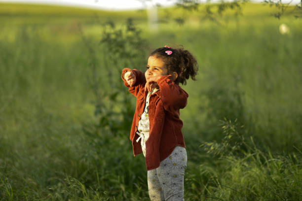 Happy little girl playing in the park, having fun, smiling
