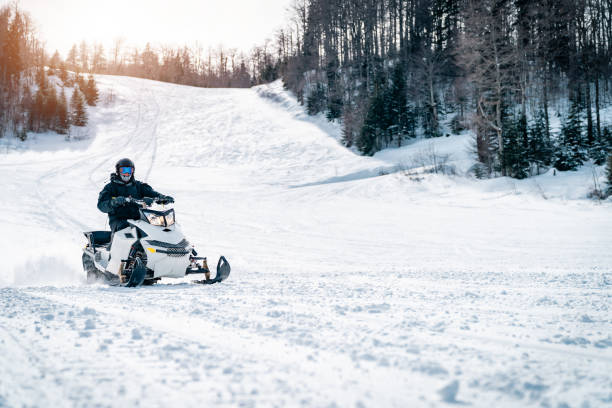 istock Young man driving a snowmobile downhill in the mountains 1540870044