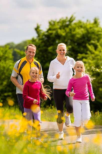 istock Young family jogging along path surrounded by flowers 154087446