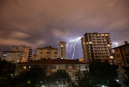 Lightning strikes between buildings at night.\nLocation : Istanbul - Turkey.