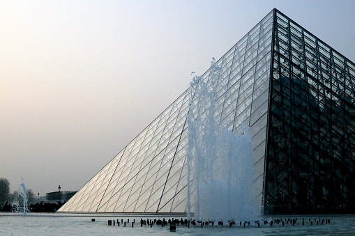 03/20/2015 Paris, France: In this captivating image, we are presented with the iconic Glass Pyramid that graces the courtyard of the Louvre Museum. Bathed in the soft glow of sunlight, this architectural marvel stands as a modern symbol of elegance and innovation amidst the historic grandeur of the museum. The pyramid's sleek lines and geometric precision are a stunning juxtaposition against the classical backdrop of the surrounding buildings. Its transparent façade allows the viewer to catch a glimpse of the bustling activity within, teasing us with the promise of the artistic treasures that lie beneath. This image encapsulates the harmonious blend of old and new, tradition and modernity, that defines the Louvre Museum. It beckons us to explore and discover the wonders that await within its walls, while reminding us of the museum's commitment to pushing boundaries and embracing the future.