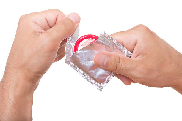 Cтоковое фото Человек открытия презерватив, изолированные на белый