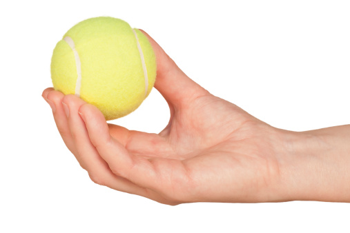 Tennis ball in hand isolated on white