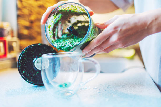 istock Young adult woman making smoothie for breakfast using blender 1540985120