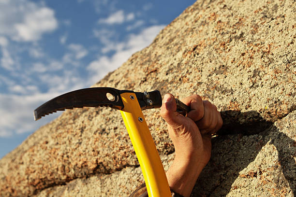 istock Hands rock-climber hammering hook in rock 154101307