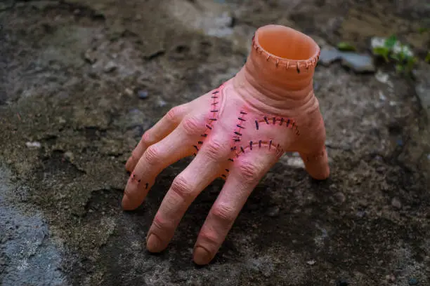 Photo of Cut off hand with active fingers. Plastic toy. Wednesday Addams movie concept.