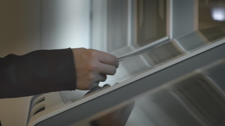 Woman puts boarding pass with document in automatic reader